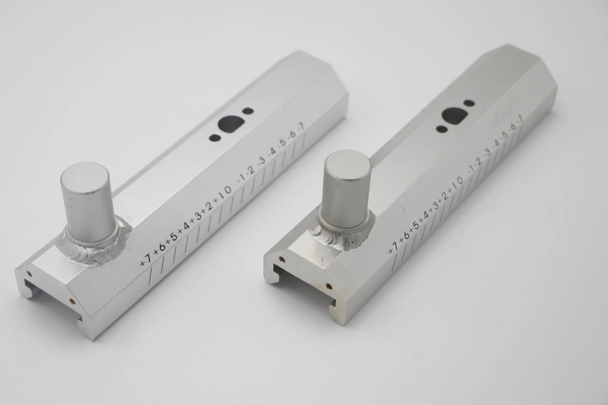 Pair of machined aluminum measuring rails with laser-marked graduated scales and turned knobs