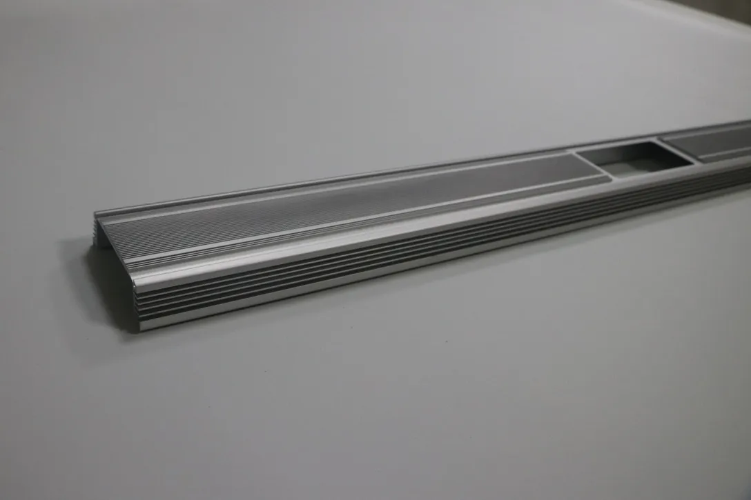 Machined extruded aluminum profile rail with milled slots and drilled mounting holes