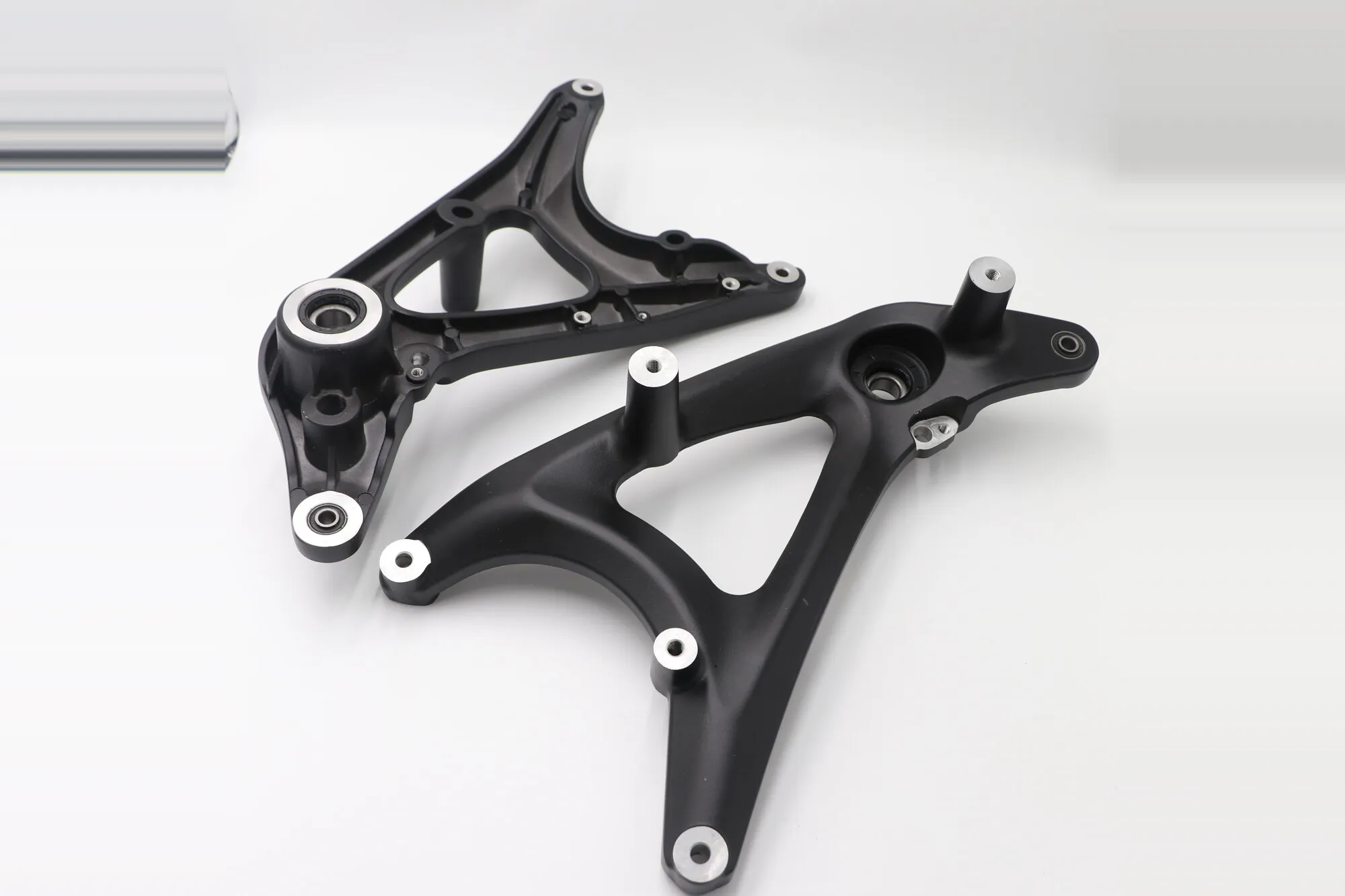 Pair of black anodized five-axis machined aluminum linkage arms