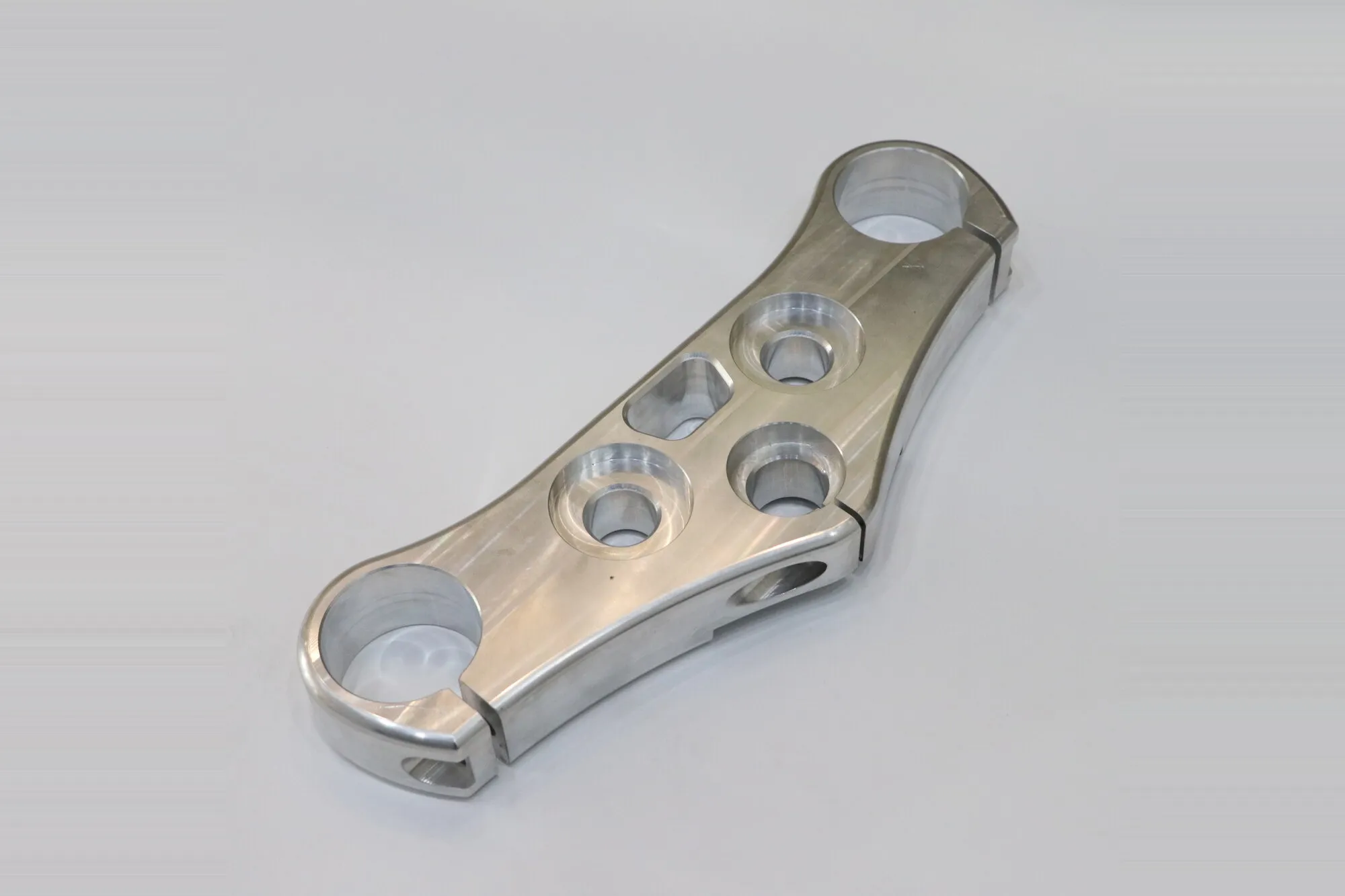 Polished five-axis CNC machined aluminum triple clamp with bored and reamed tube seats